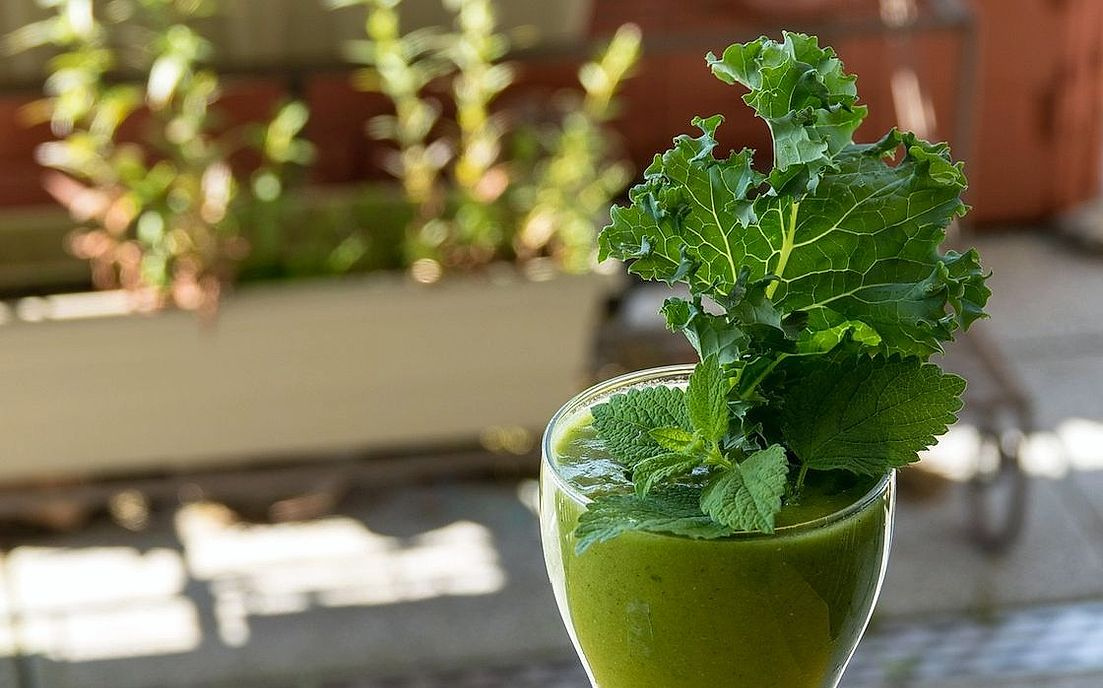 A fresh-pressed green juice with a frothy top